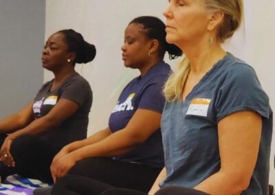 women sitting on floor cross legged with their eyes closed