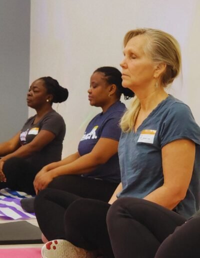 women sitting on floor cross legged with their eyes closed