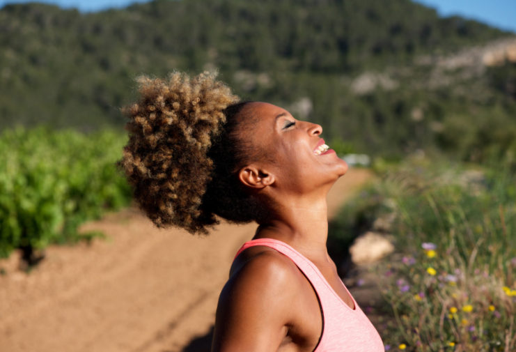 woman looking at the sky with closed eyes smiling